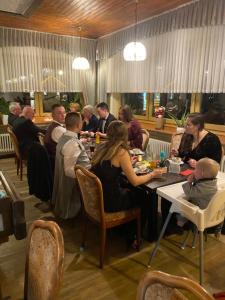 比尔斯多夫Hotel-Restaurant Theis-Muehle的一群坐在餐厅桌子上的人