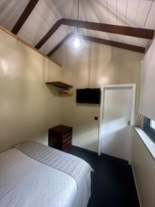 马希库Quiet Place的卧室配有一张床,墙上配有电视。