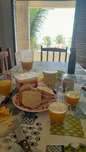 皮帕Pelados Beach Hostel的一张桌子,上面放着一盘面包和橙汁