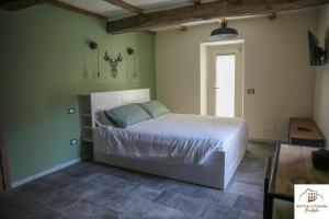 BusanaAntica Locanda Bonfiglio的卧室设有一张位于绿色墙壁上的床铺