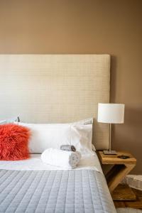 多伦多Gabby's Place Downtown Core的卧室配有白色的床、红色枕头和灯