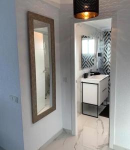 蓬塔普里马Modern penthouse with sea view的浴室设有水槽和墙上的镜子