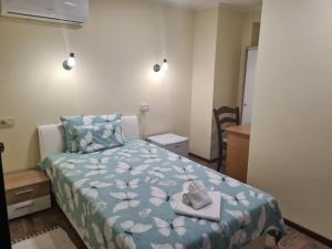 克宁SLATKI SNOVI II的一间卧室配有一张带蓝色棉被的床和2条毛巾