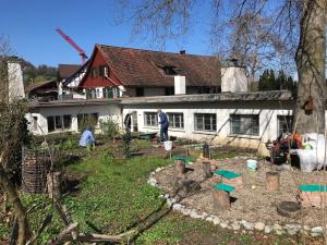 FlaachStudio beim Rhein - Ziegelhütte的一座花园,位于一座有工人的房屋前