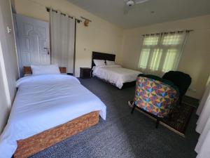 罕萨Hunza Lounge的一间卧室配有两张床和椅子