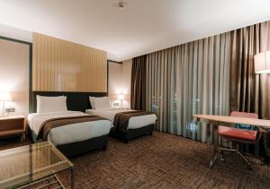 特拉布宗Invite Hotel Corner Trabzon的酒店客房配有两张床和一张书桌