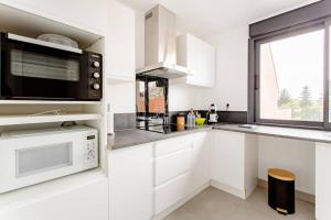 摩兰吉斯Joli appartement proche Paris Orly的一间配备了微波炉和窗户的白色厨房