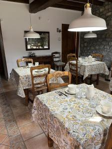 ToñanesPosada San Tirso的一间用餐室,配有两把桌椅、盘子和碗