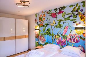 格伦德霍夫Appart-Hotel Ernz Noire的卧室的墙上挂着花卉壁画