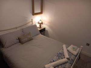 滨海绍森德Luxury holiday home, near beach的卧室配有一张白色床和一张桌子上的台灯