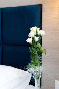 下乌斯奇基Lynks Resort的花瓶,花瓶上满是白色的花朵,坐在桌子上