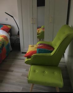 塞纳河畔勒梅Agréable chambre indépendante chez Virginie&Henri的一张绿色椅子,位于带床的房间