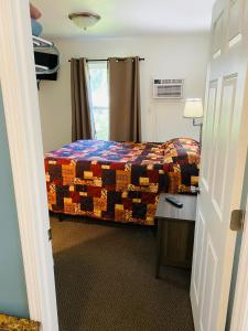 缪尼辛Scotty's Motel的一间卧室配有一张床、一张桌子和一个窗户。