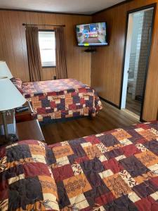 缪尼辛Scotty's Motel的酒店客房设有两张床和一台平面电视。