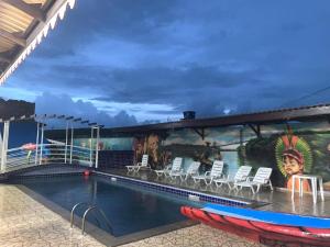 OiapoqueHotel La Villa Morena的游轮上的游泳池,带椅子和壁画