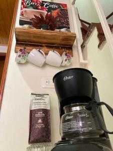 波哥大Como en casa的咖啡壶的柜台和墙上的杯子