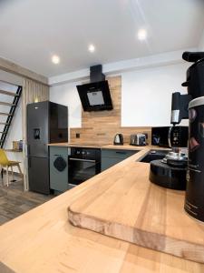 鲁昂Eco-Appart'hôtel Rouen / SLT的厨房配有木制台面和冰箱