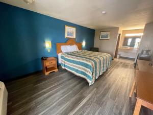 科珀斯克里斯蒂Airport inn & suites的一间卧室设有一张床和蓝色的墙壁