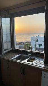 阿列塔La Casa del Atlántico的带水槽的厨房窗户,享有海景