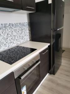 雅西Bucium Apartament的厨房配有不锈钢冰箱和白色柜台 顶部