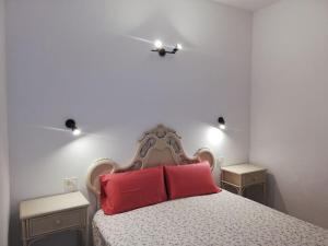 塔扎克蒂apartamento CASA TELA的一间卧室配有一张带两个红色枕头的床