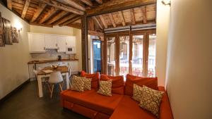 托莱多Tiempo de Toledo的一间带橙色沙发的客厅和一间厨房