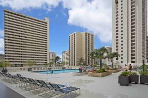 檀香山The Whale Suite @Waikiki Banyan (1 Free Parking)的一座带躺椅的游泳池以及建筑