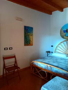 兰佩杜萨A due passi da Cala Pisana的一间卧室,卧室内配有一张床和一把椅子