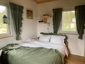OsiekRóżana Zagroda Agroturystyka的卧室内的一张床位,设有两个窗户