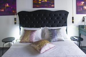 费拉拉Boutique Hotel Ferrara的一张带黑色床头板的床和两个枕头
