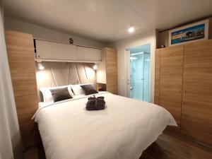 德拉格Zen Zone Premium Mobile Home的卧室配有一张白色大床,背包上