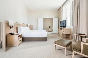珀斯COMO财富酒店的酒店客房,配有床和电视