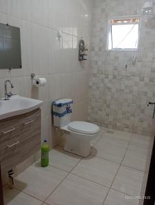 瓜拉廷格塔CHÁCARA TERRA dos SONHOS的浴室配有卫生间、盥洗盆和淋浴。