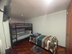 里奥班巴Hermosos Departamentos con Vista a los Nevados的一间卧室配有一张床和一台电视。