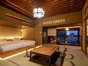 尾道市Ryokan Onomichi Nishiyama的一间卧室配有一张床和一张木桌