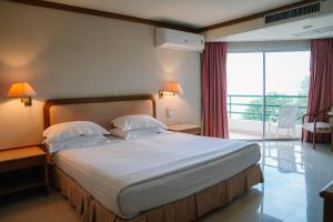 卡农卡农金色海滩酒店的酒店客房设有一张大床和一个阳台。