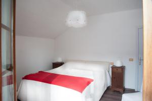 大圣玛丽亚Chalet La Primula的卧室配有一张带红色毯子的白色床