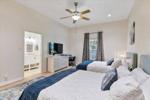 休斯顿LUCKY House - Tranquility in the Middle of Houston - TV in every room - 300 m2的一间卧室配有两张床和吊扇