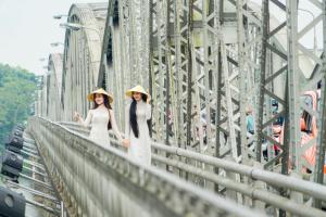 顺化卡萨布兰卡酒店的两个戴帽子的女人站在桥上