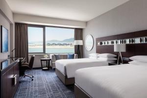 香港天际万豪酒店的酒店客房设有两张床和大窗户。
