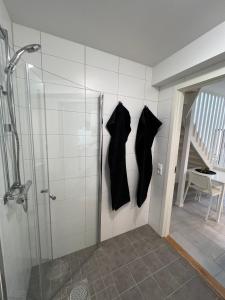 哈尔姆斯塔德Stugcentralen Lägenheter & Stugor的墙上挂着两件黑色衬衫的淋浴