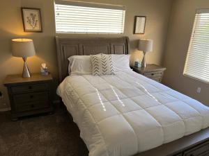 拉斯克鲁塞斯Spacious, comfortable & relaxing home 4的一间卧室配有一张带2个床头柜的大型白色床