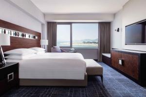 香港天际万豪酒店的一间酒店客房,设有一张大床和一个大窗户