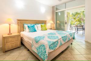 棕榈湾Oasis 8 at Palm Cove的一间带大床的卧室和一个阳台