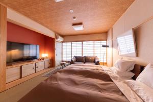 佐贺市Tsukasa Ryokan的一间卧室配有一张大床和一台平面电视