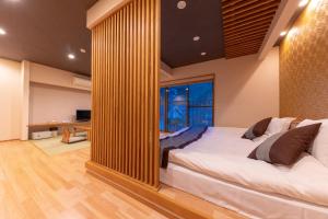 佐贺市Tsukasa Ryokan的一间卧室配有一张大床和大镜子