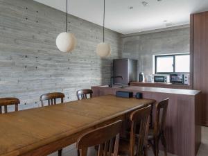 读谷村Bosco Yomitan Resort Condminium的厨房配有大型木桌和椅子