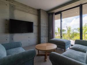读谷村Bosco Yomitan Resort Condminium的客厅配有2张沙发和1台平面电视
