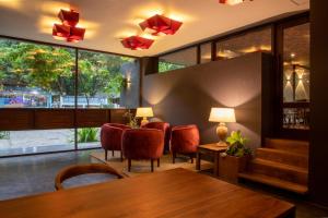 康提Lake Avenue Hotel Kandy的一间带桌椅和大窗户的用餐室