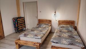 凯斯特海伊Zimmerferi Apartman Keszthely的一间卧室配有两张床和椅子